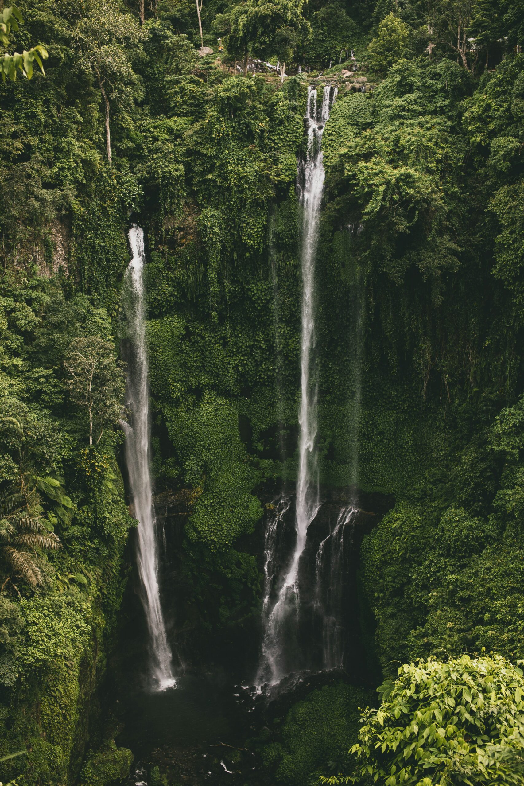 Kavanaia. Cascade entourée de végétation tropicale à Java, Indonésie, avec eau cristalline et rochers