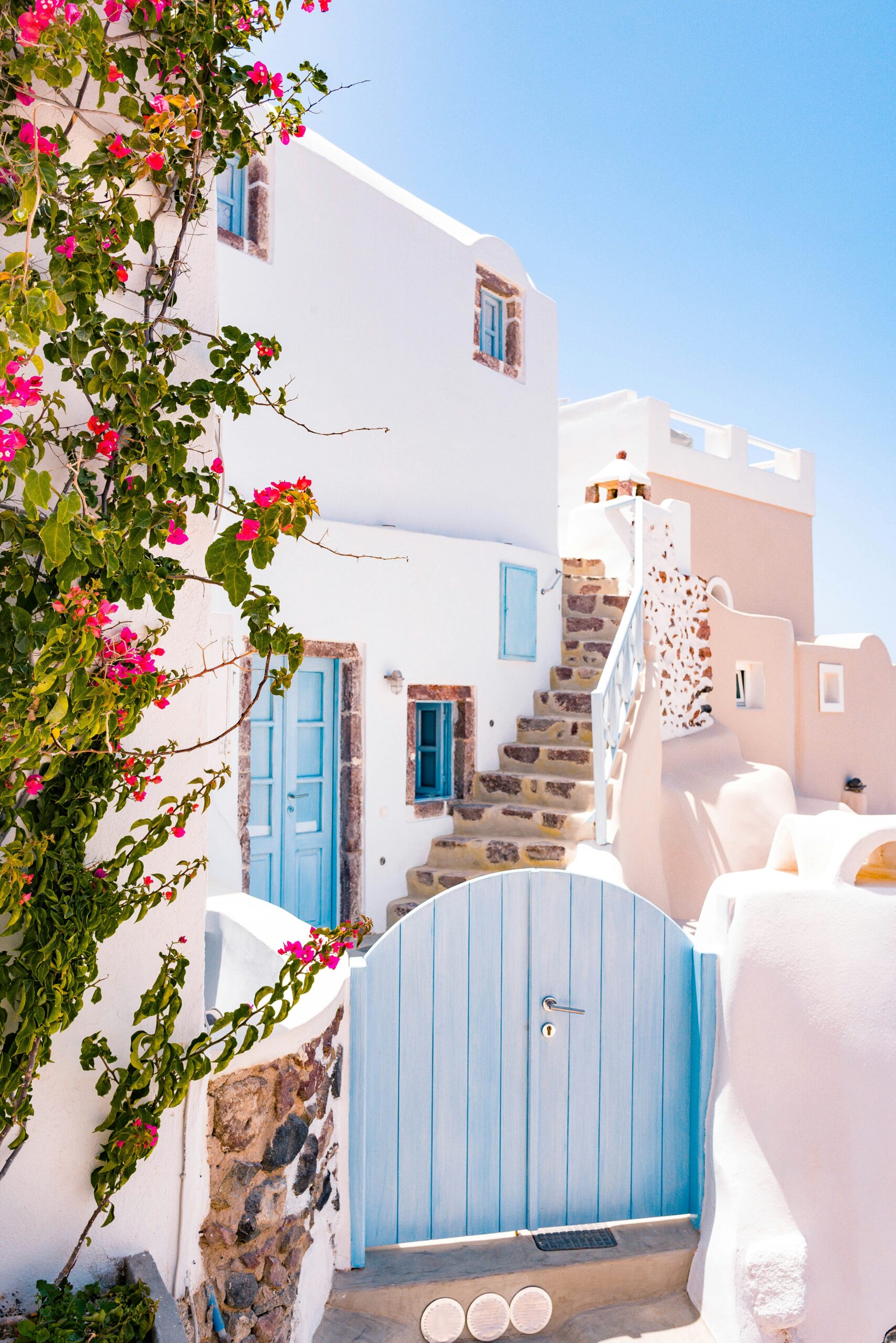 Nos packs de voyage sur mesure. Paysage de Santorin, Grèce, avec ses maisons blanches et ses eaux cristallines, idéal pour un voyage inoubliable.